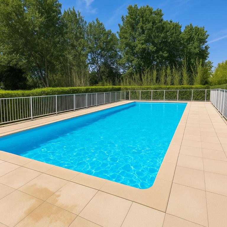 une piscine d'eau bleue et une clôture dans l'établissement Mandelieu vacances RDC jardin, piscine, parking 2 chambres, à Mandelieu-la-Napoule