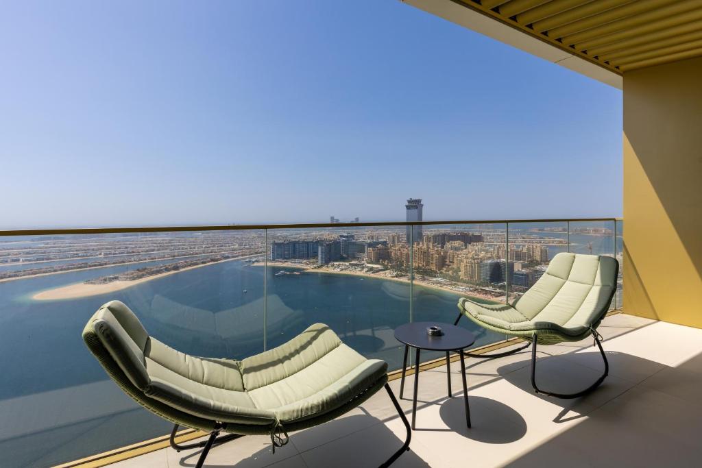 una vista dall'alto di un edificio con sedie e una piscina di Maison Privee - Coastal Living with Uninterrupted Sea & Palm Views a Dubai