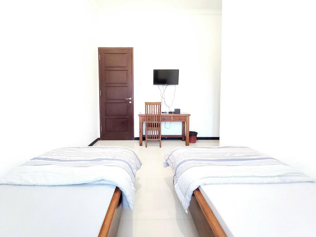 Postel nebo postele na pokoji v ubytování D Maktab Homestay Syariah Mitra RedDoorz near Soekarno Hatta Street Malang