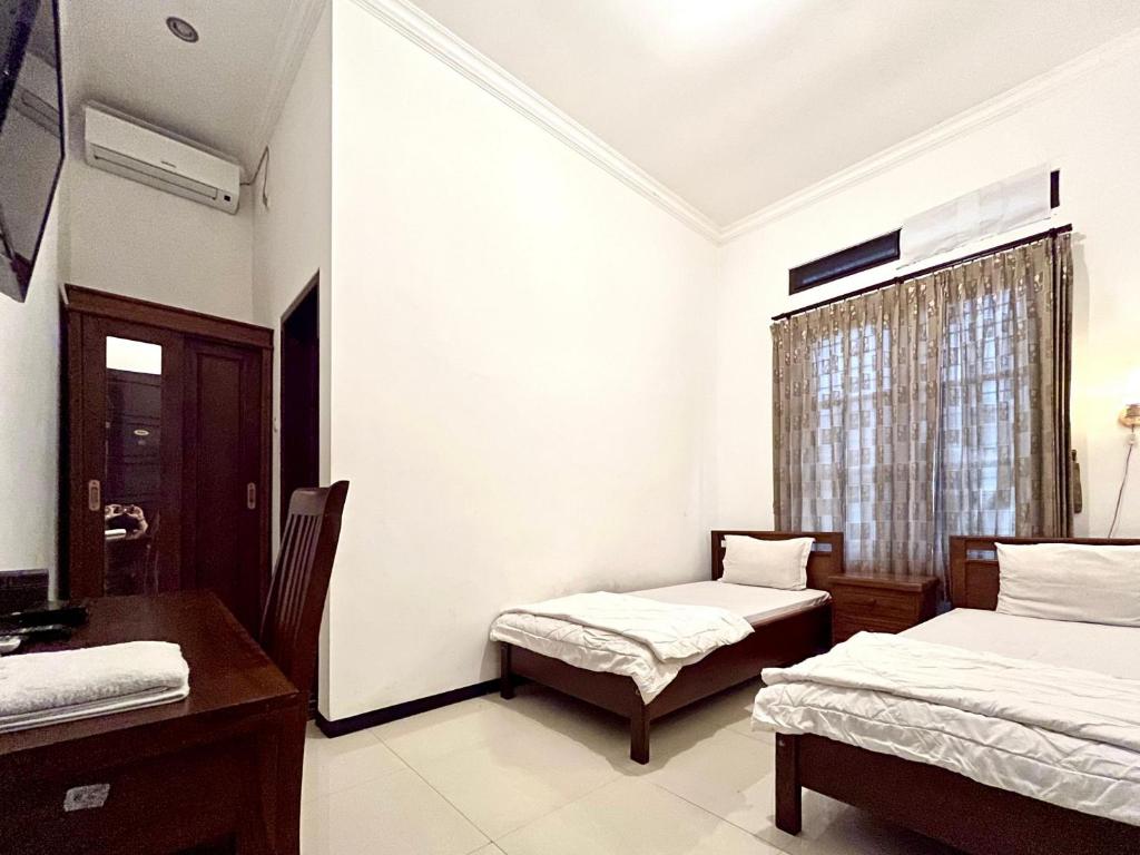 Postel nebo postele na pokoji v ubytování D Maktab Homestay Syariah Mitra RedDoorz near Soekarno Hatta Street Malang