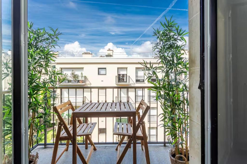 une table et des chaises sur un balcon avec vue sur un immeuble dans l'établissement Très bel Appartement Neuilly, à Neuilly-sur-Seine
