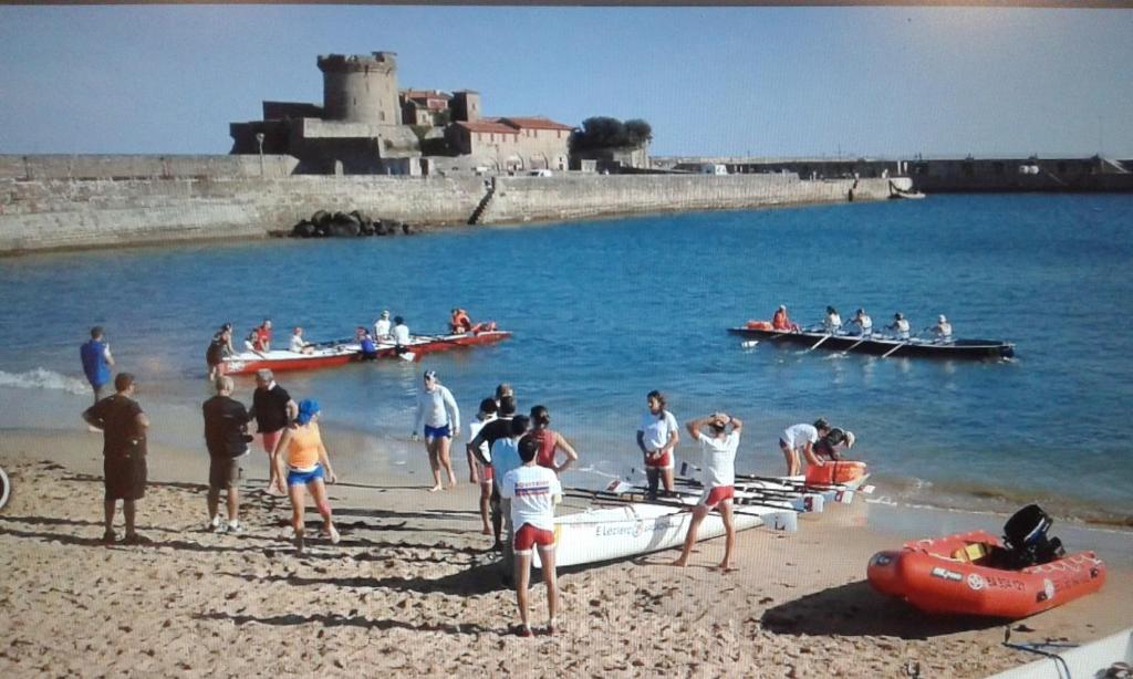 un groupe de personnes sur une plage avec des bateaux dans l'eau dans l'établissement kantari, à La Celle-sous-Gouzon