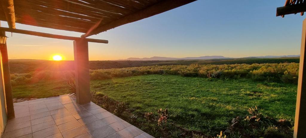 a view of the sunset from the porch of a house at Living The Breede - Inhoek Farm Gatehouse in Malgas
