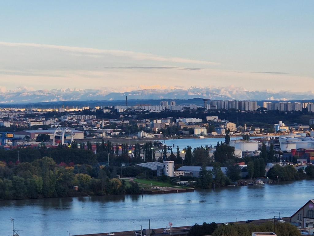 une vue d'une ville avec une rivière dans l'établissement T4/5 avec vue sur les Alpes à 5 minutes de Lyon, à La Mulatière