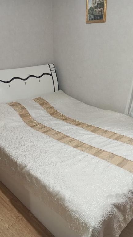 a bed with white sheets and a wooden head board at Dosoy in Bosteri
