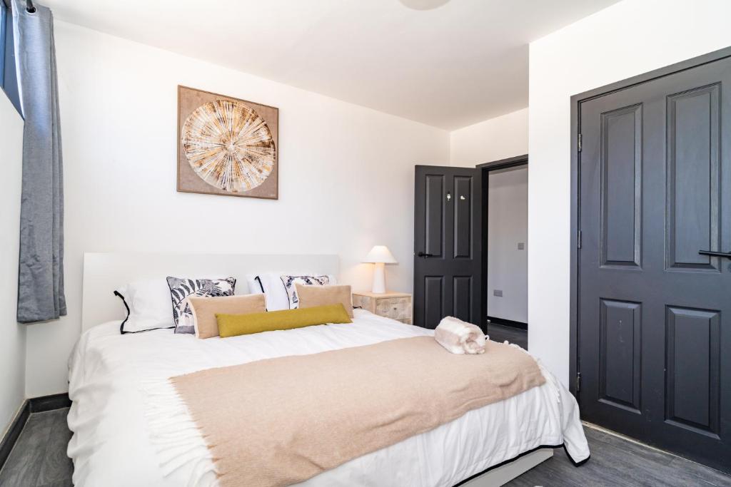 a bedroom with a large white bed and a black door at Penthouse City Centre Apartment in Royal Tunbridge Wells
