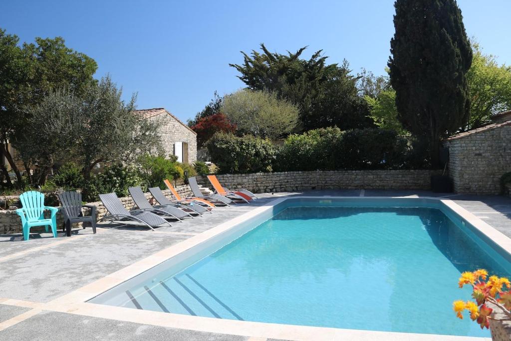 Una piscina con tumbonas al lado de una casa. en VILLA DEL RE 1 dans résidence avec piscine, en La Flotte