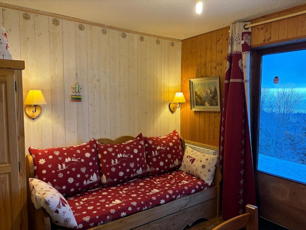 - un canapé rouge dans une pièce avec fenêtre dans l'établissement Le Panoramique I Studio, à Thollon-les-Mémises