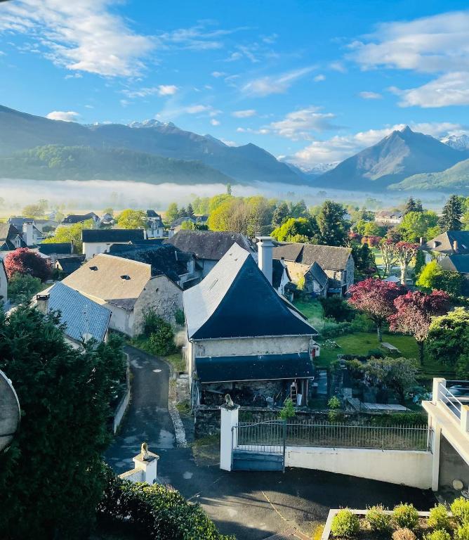 une vue aérienne sur un village avec des montagnes en arrière-plan dans l'établissement Pyrénées studio, vue, piscine, à Ayzac-Ost