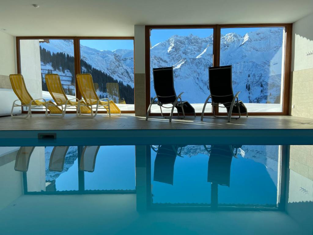 Zimmer mit Stühlen und einem Tisch mit Bergblick in der Unterkunft Appartment Schröcken in Schröcken