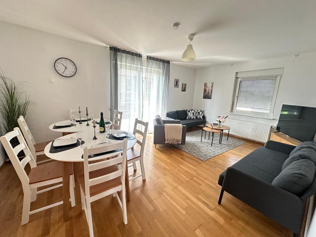 a living room with a table and a dining room at W24 - 8 Einzelbetten - 6 Schlafzimmer - Wohnzimmer & große Terrasse - 2 Bäder - Wohnung auf 2 Ebenen - Nähe Messe Stuttgart & A81 - Ideal für Teams & Monteur in Böblingen