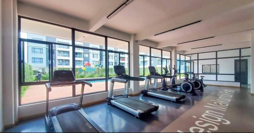 a gym with a row of treadmills and windows at Polar homes in Nairobi