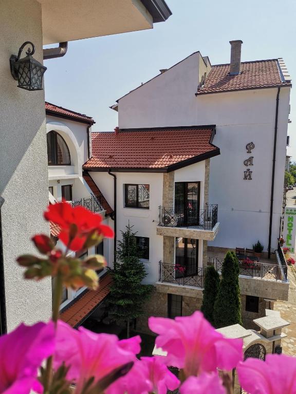 a house with pink flowers in front of it at Family Hotel Rai in Shumen