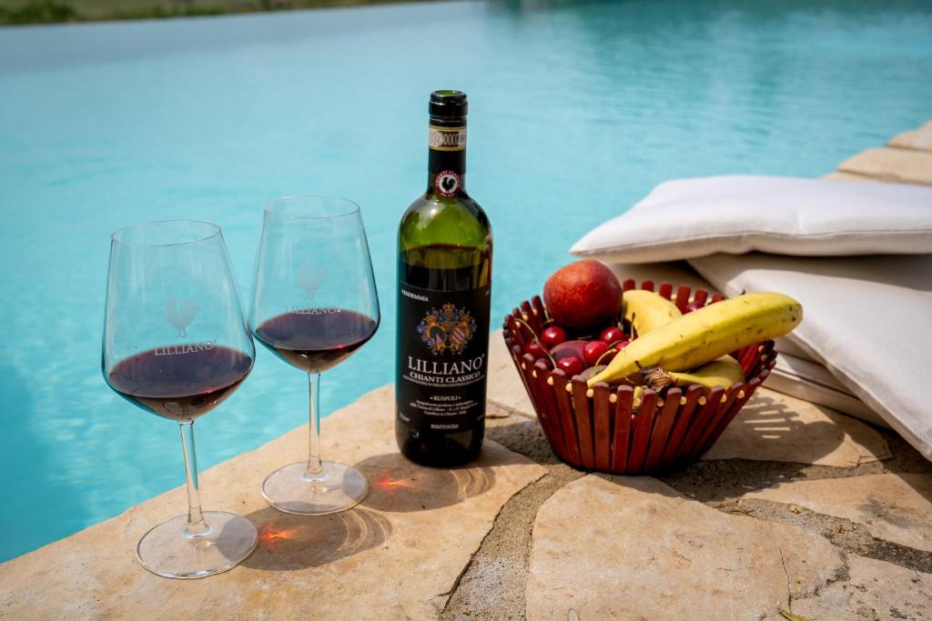 - deux verres de vin et une corbeille de fruits sur une table dans l'établissement In The Heart Of Chianti, Pool, Wifi, View - Lilliano, à Castellina in Chianti