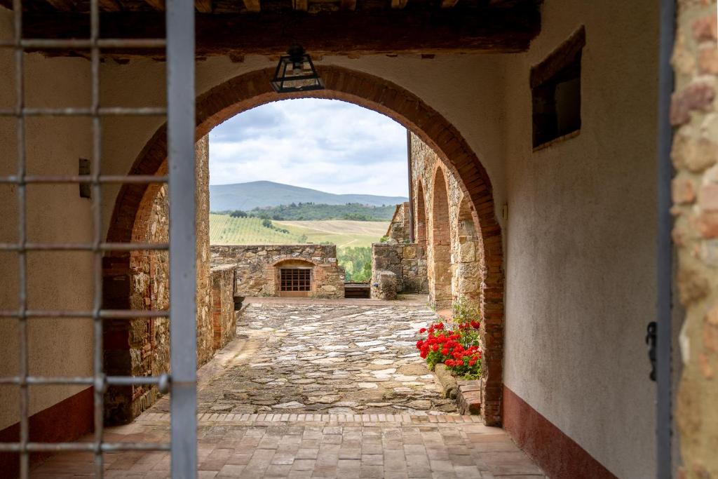 une arche dans un bâtiment en pierre avec vue dans l'établissement In The Heart Of Chianti, Pool, Wifi, View - Lilliano, à Castellina in Chianti