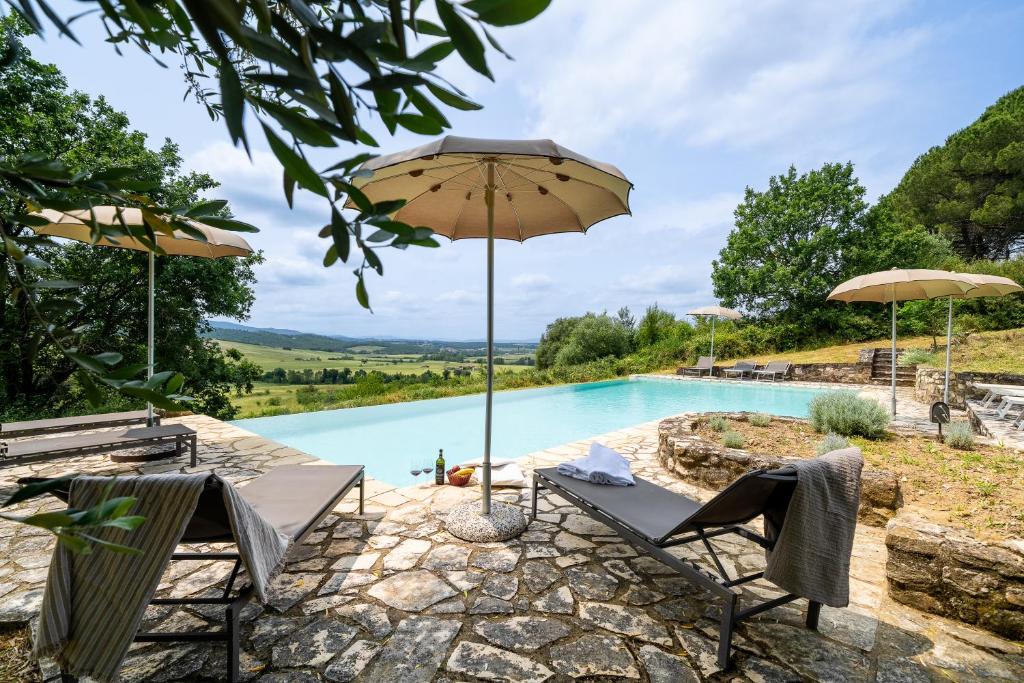 - une piscine avec 2 chaises et un parasol dans l'établissement In The Heart Of Chianti, Pool, Wifi, View - Lilliano, à Castellina in Chianti