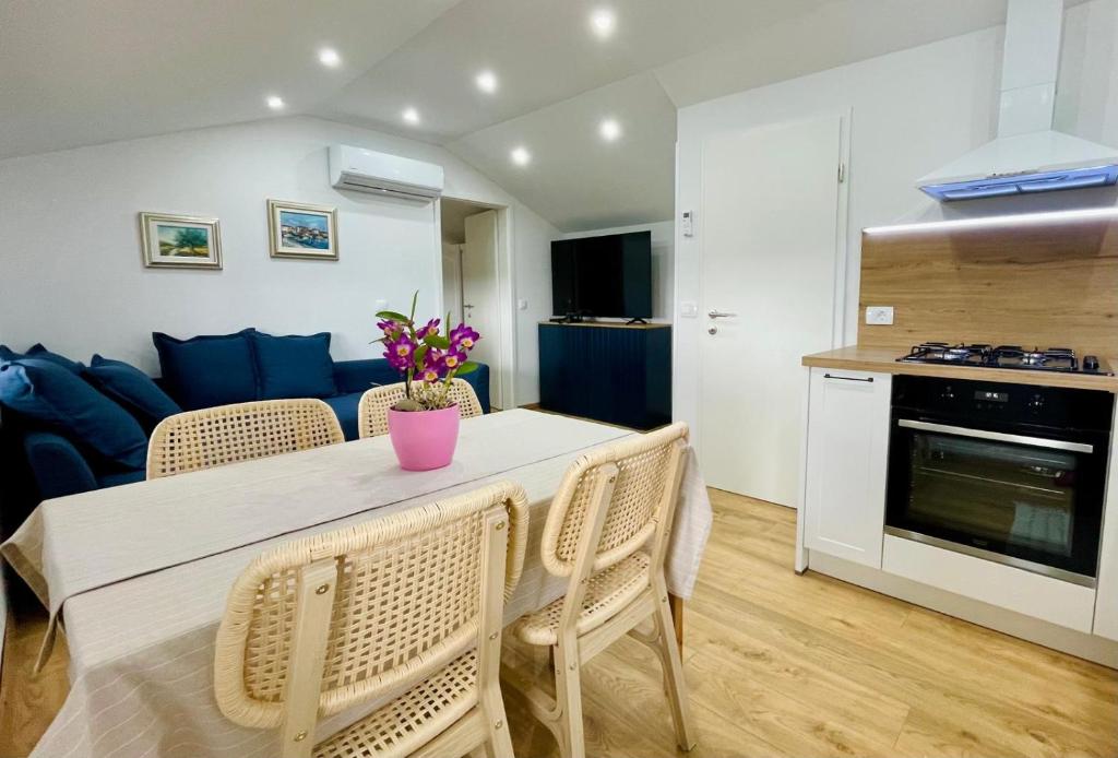 a kitchen and a living room with a table and chairs at Vista Mare in Kaštel