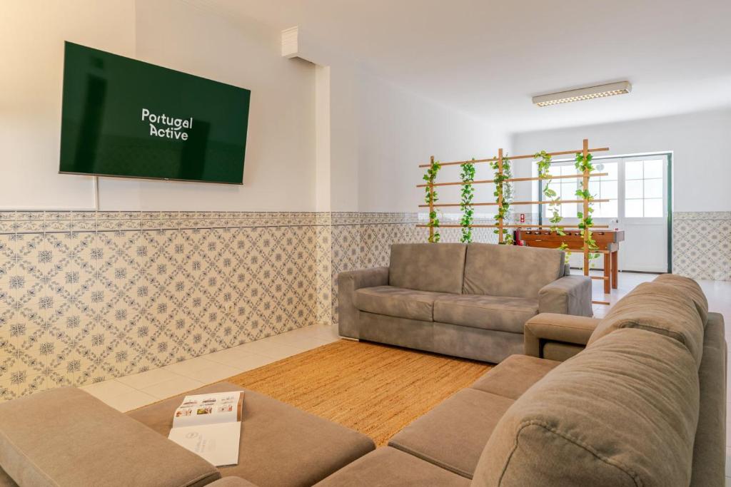 a living room with a couch and a tv at Portugal Active Bandeira Retreat in Viana do Castelo