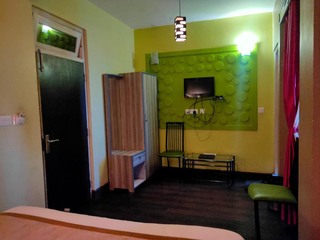 a room with a bed and a green wall at Bon The Rink Heritage in Darjeeling