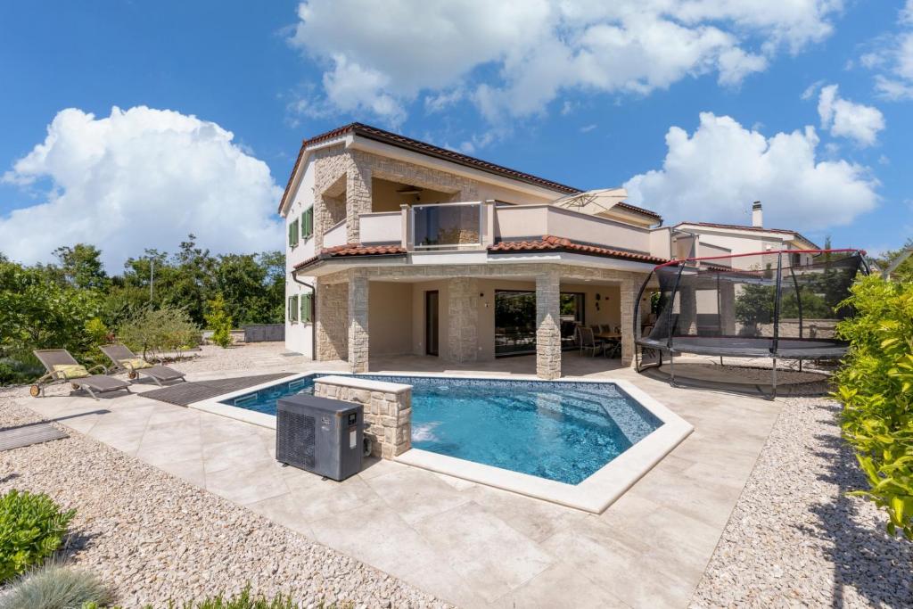 a house with a swimming pool in the yard at Villa Divina in Milohnići