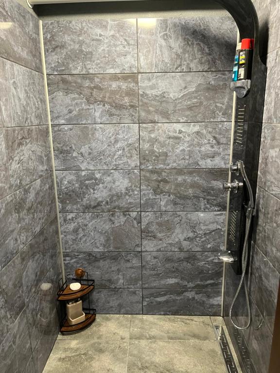 a bathroom with a shower with a stone wall at The Byala Escape, Private Villa with Bar & Hot Tub in Byala