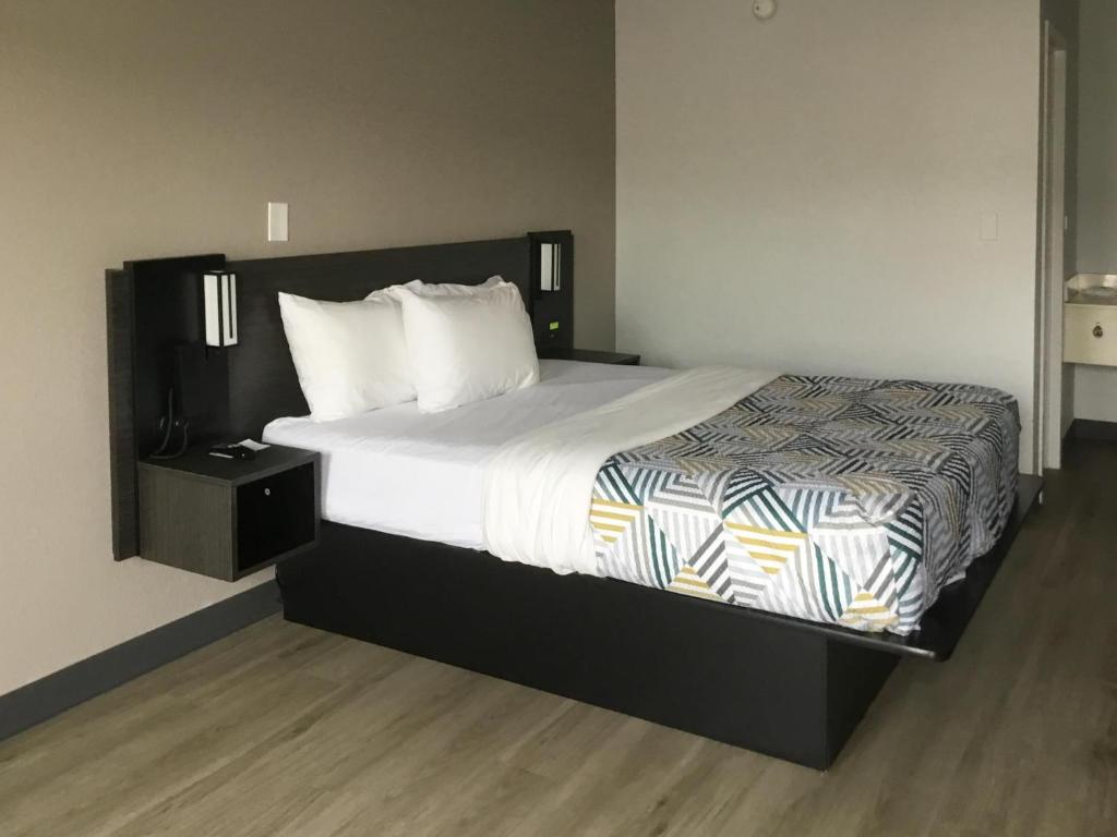 a bedroom with a large bed with white sheets and pillows at Motel 6-Farmington Hills, MI - Northwest - Farmington Hills in Farmington Hills