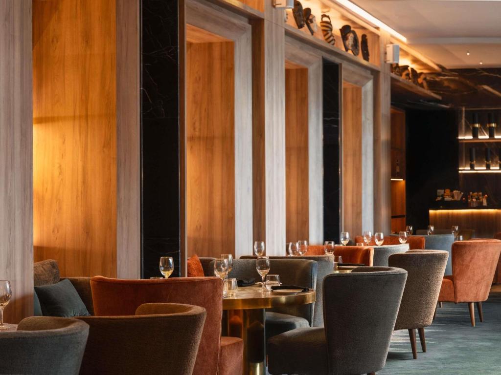 a restaurant with tables and chairs and wine glasses at Sofitel Casablanca Tour Blanche in Casablanca