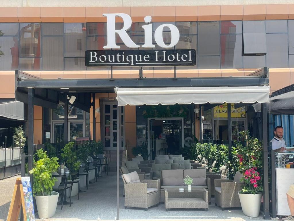 ein Restaurant mit Tischen und Stühlen vor einem Gebäude in der Unterkunft Rio Boutique Hotel Vlore in Vlorë