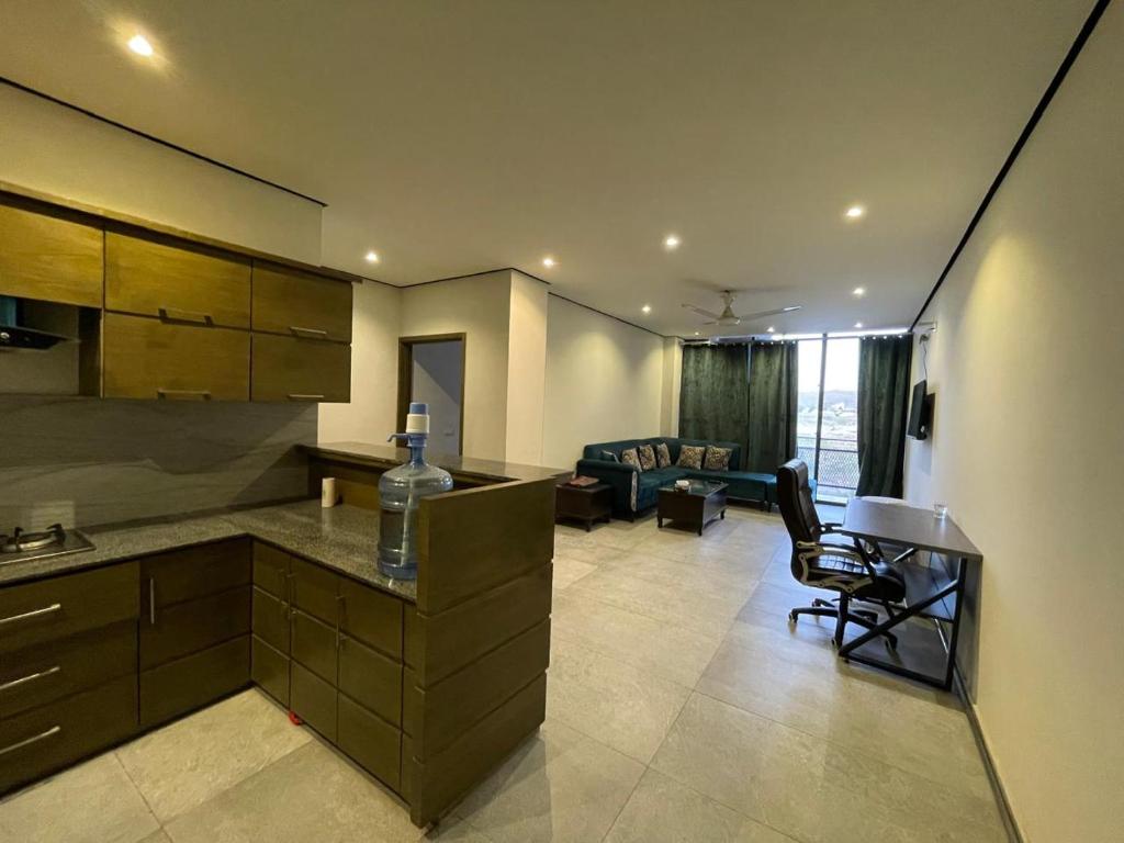 a kitchen and living room with a table and a couch at Sunrise Villa in Islamabad