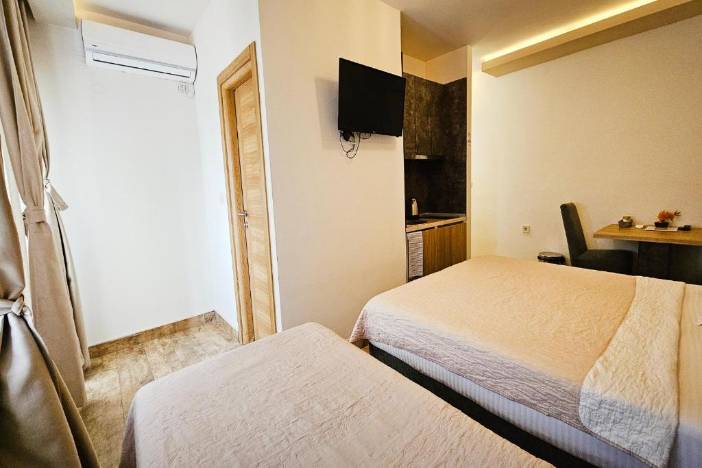 a small hotel room with two beds and a table at Villa Montemaris Budva in Budva