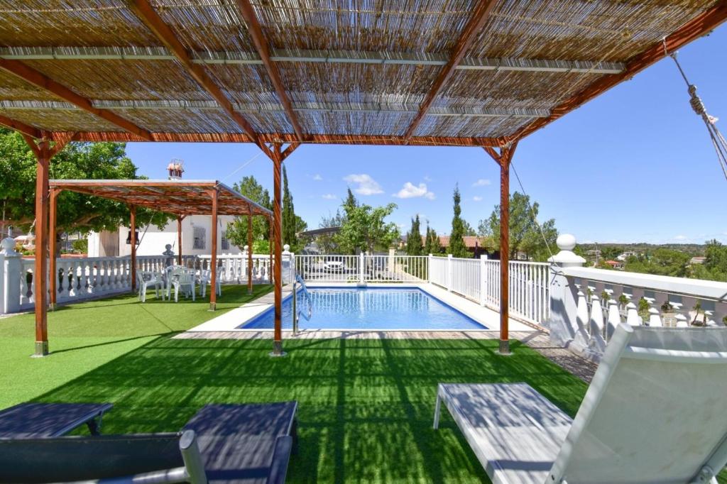 a patio with a swimming pool and a pergola at Exclusive Villa in Catadau: Pool & Private Gardens in Catadau