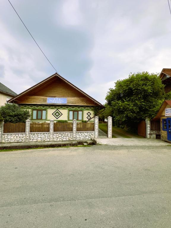 a house with a fence in front of it at ILEANA Săpânța in Săpânța