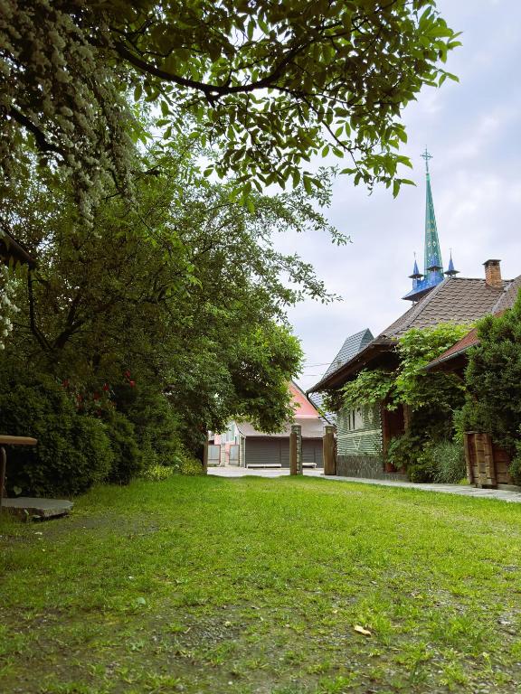 a yard in front of a house with a church at ILEANA Săpânța in Săpânța