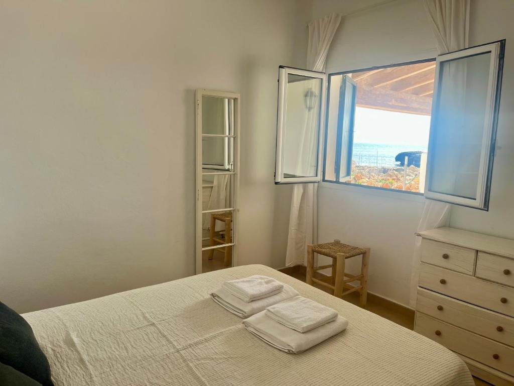 a bedroom with a bed with two towels on it at Villa Calma in Cala'n Bosch