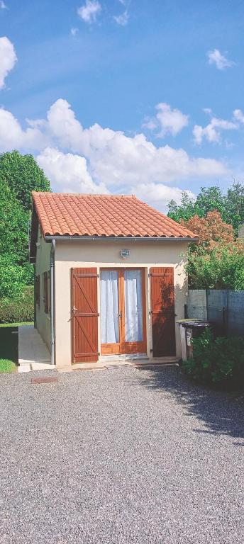 une petite maison avec un toit rouge dans une allée. dans l'établissement Maison T2 indépendante avec terrasse et parking, à Buxerolles