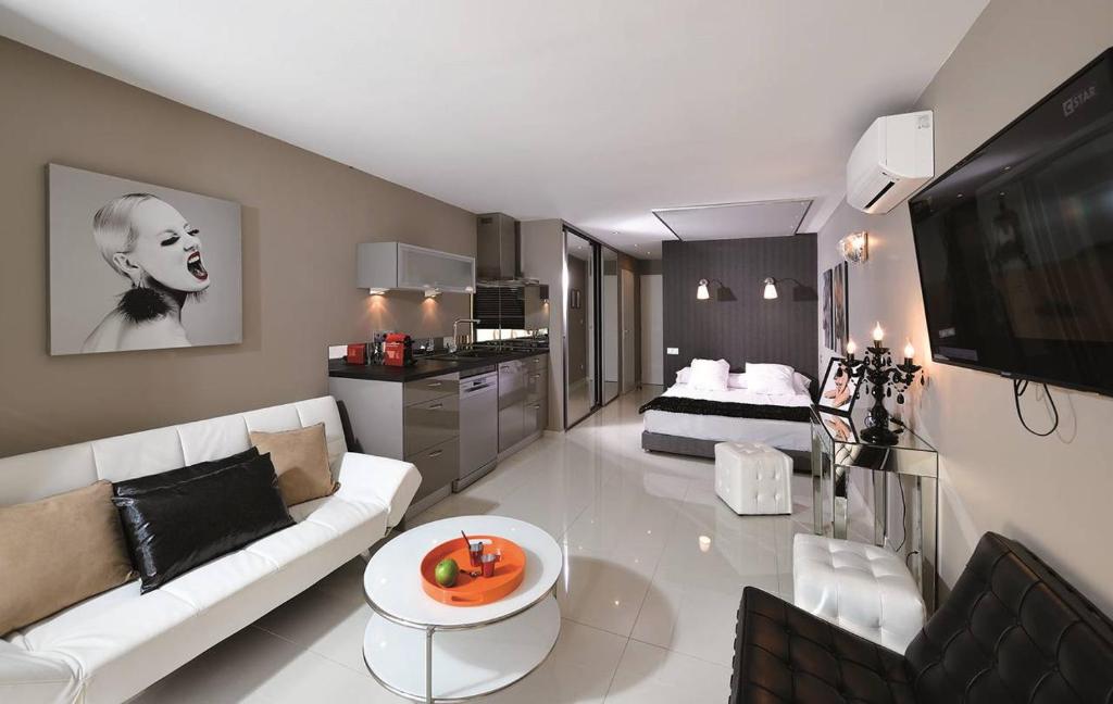 - un salon avec un canapé blanc et un lit dans l'établissement Appartement KERYLOS Héliopolis K3 - Luxe 2 personnes, au Cap d'Agde