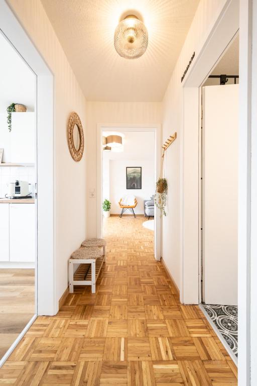 a hallway with a wooden floor and white walls at Altstadt Auszeit in Freiburg im Breisgau