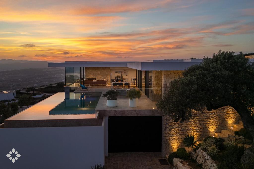 a house with a sunset in the background at Villas Aloe Vera by Abahana Luxe in Benitachell
