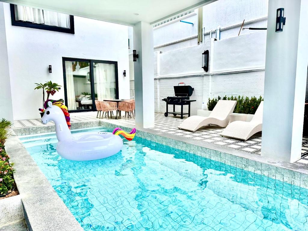 ein Swimmingpool mit einem aufblasbaren Schwan in einem Haus in der Unterkunft Sun Sky Villa 6 Bed Pool BBQ KTV Group Friendly - 7 in Pattaya South