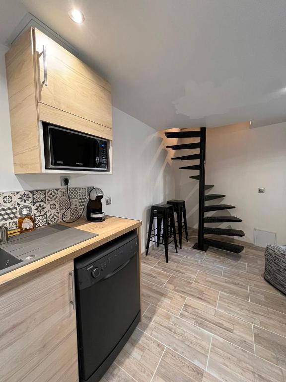 une cuisine avec un lave-vaisselle et un escalier en arrière-plan dans l'établissement La petite maison du gardien, à Avignon