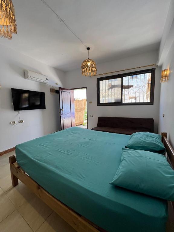 sypialnia z dużym zielonym łóżkiem z żyrandolem w obiekcie A bohemian-style studio in dahab w mieście Dahab