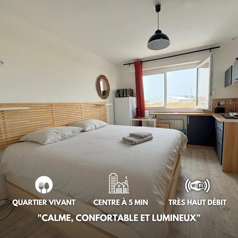 une chambre avec un grand lit et une fenêtre dans l'établissement Studio Île de Groix - Escape to Lorient, à Lorient