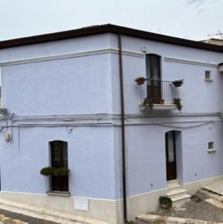a white building with two windows and a balcony at Foresteria del Borgo Antico in Ascoli Satriano