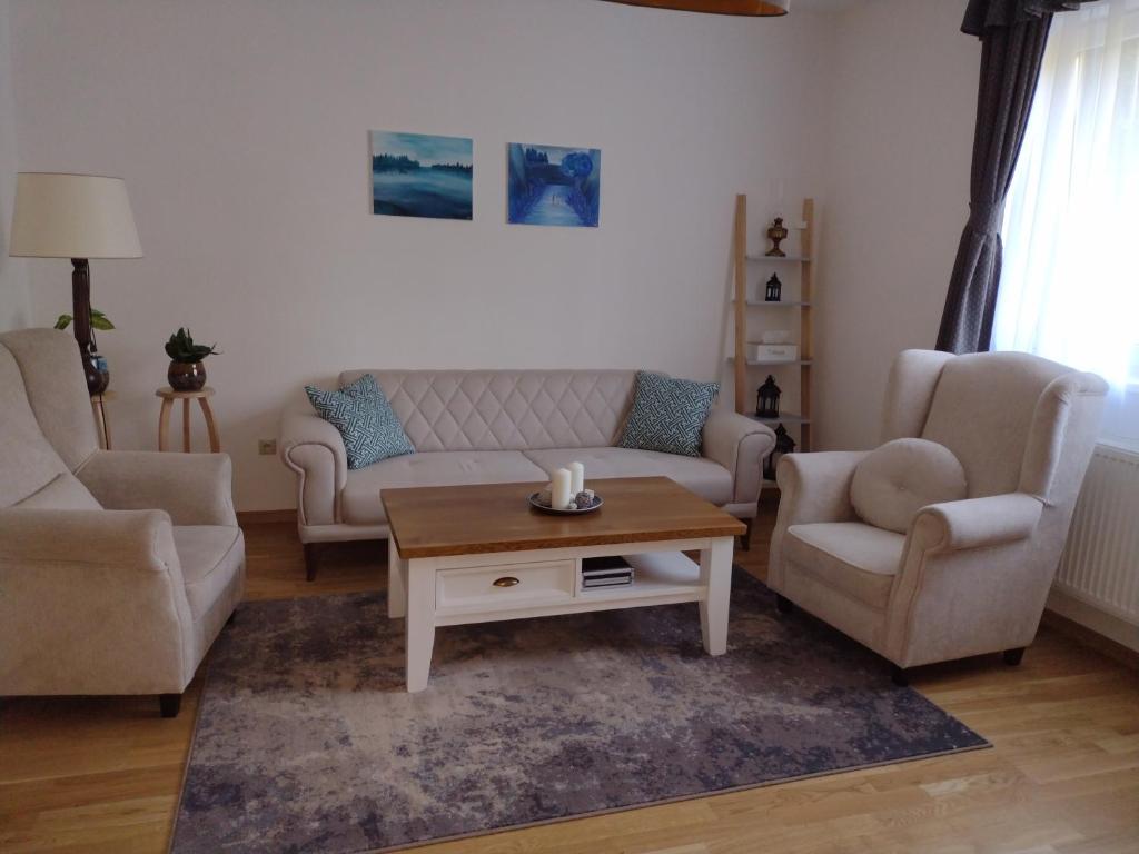 Una sala de estar con un sofá y dos sillas y una mesa de café. en Bara ház, en Tvrdošovce