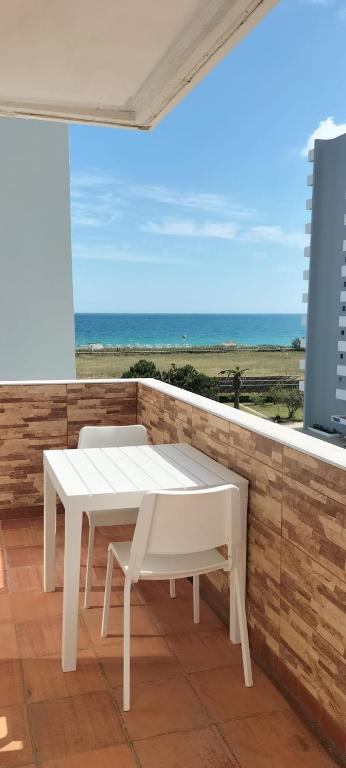 a white table and chairs on a balcony with the ocean at Sol e Praia Alvor 1 in Alvor