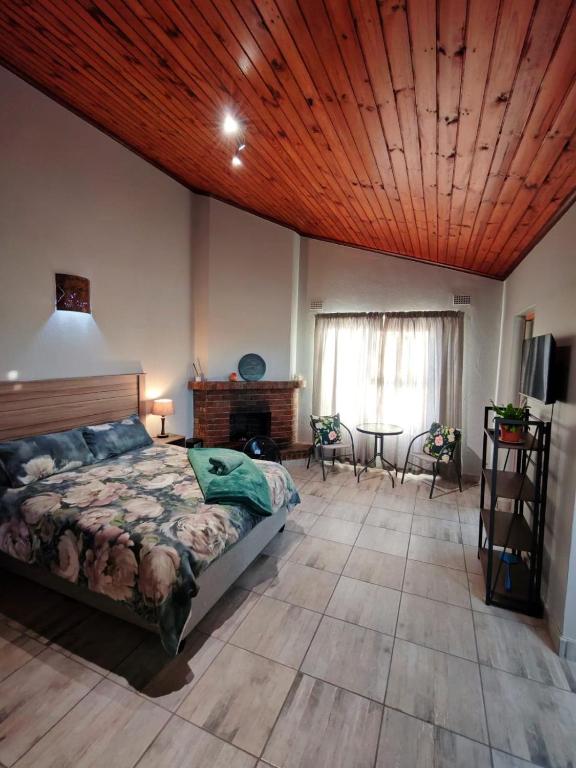 a bedroom with a bed and a wooden ceiling at Sunbird Studio Apartment in Brackenfell