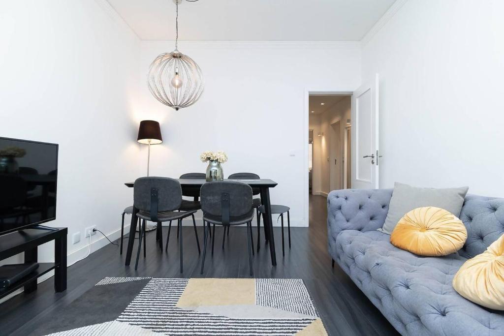 a living room with a blue couch and a table at Lisbon Hideaway near the River in Lisbon