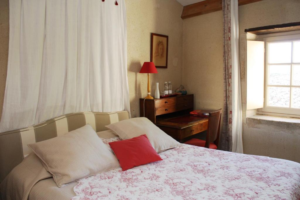 une chambre avec un lit, un bureau et une fenêtre dans l'établissement Chateau De Castelneau, à Saint-Léon