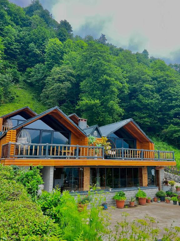 a large wooden house with a large deck at Masal Suit in Çamlıhemşin