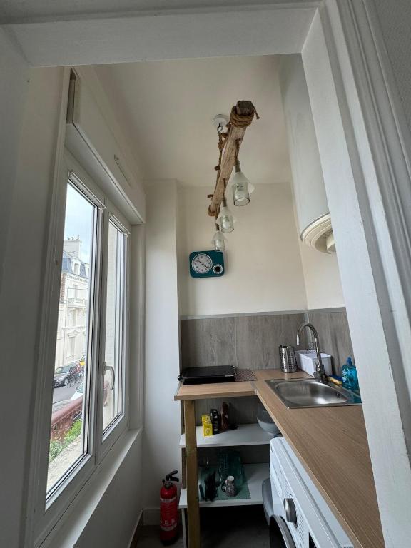 a small kitchen with a sink and a window at Le 27 Deauville in Deauville